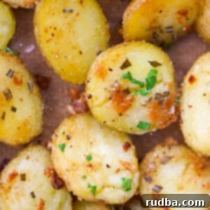 Golden Roasted Baby Spuds 2 Close-up of golden brown roasted baby potatoes with visible garlic and rosemary