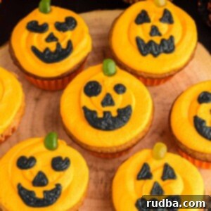 Carved Pumpkin Cupcake Delights 2 Seven Jack-O-Lantern cupcakes on a wooden board.