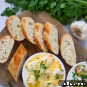 lobster cargot on a wooden board with bread and parsley on the side.