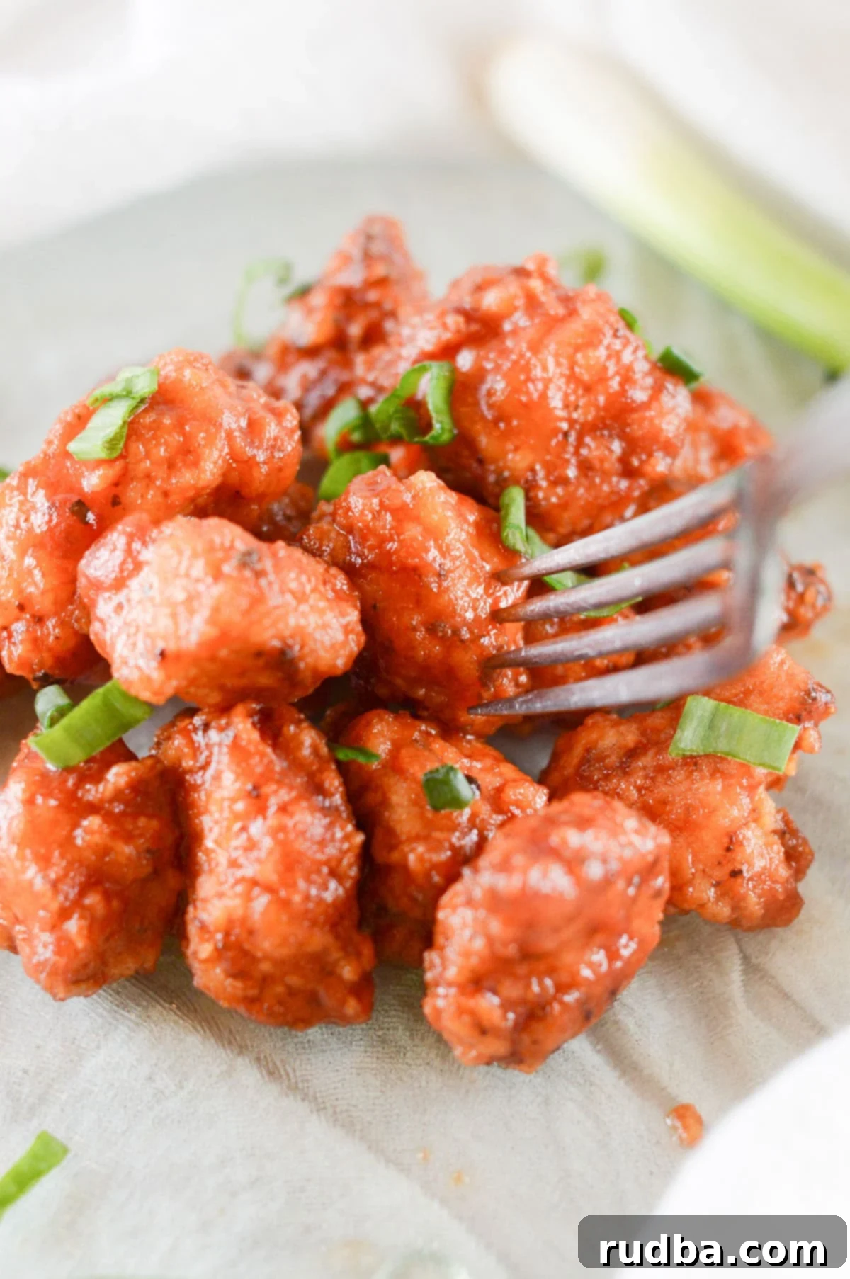 boneless wings coated in barbecue sauce with a fork 