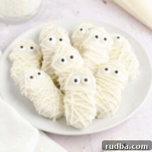Nutter Butter Mummy Treats 2 nutter butter mummies on a white plate.