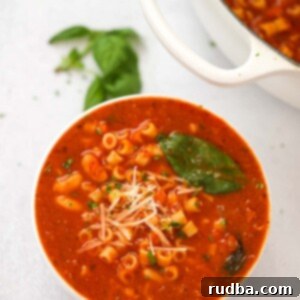 pasta fagioli soup in a bowl with a pot on the side.