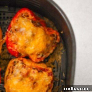 Crispy Air Fryer Stuffed Peppers 2 Two stuffed peppers in the air fryer basket up close.