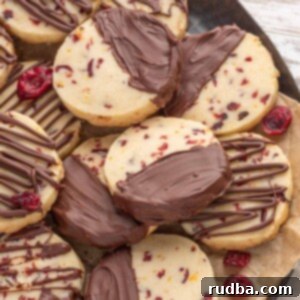 Zesty Cranberry Chocolate Shortbread 2 Chocolate cranberry orange shortbread cookies on a plate.