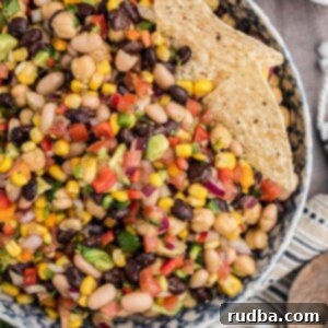 Fiesta Bean Salad 2 A close-up of a bowl of fresh Cowboy Caviar, showing the vibrant colors of beans, corn, tomatoes, and cilantro.