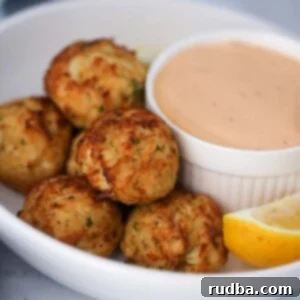 crab bites with a side of remoulade sauce and a lemon wedge.