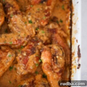 Tender Smothered Turkey Wings 2 Smothered turkey wings and legs in a baking dish up close.