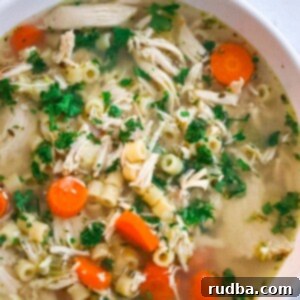 A close-up of a steaming bowl of delicious chicken ditalini soup, ready to eat.