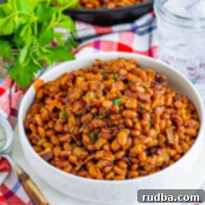 Hearty Homestyle Beans 2 A bowl of baked beans with crispy bacon on top, garnished with fresh herbs, a perfect hearty side dish.
