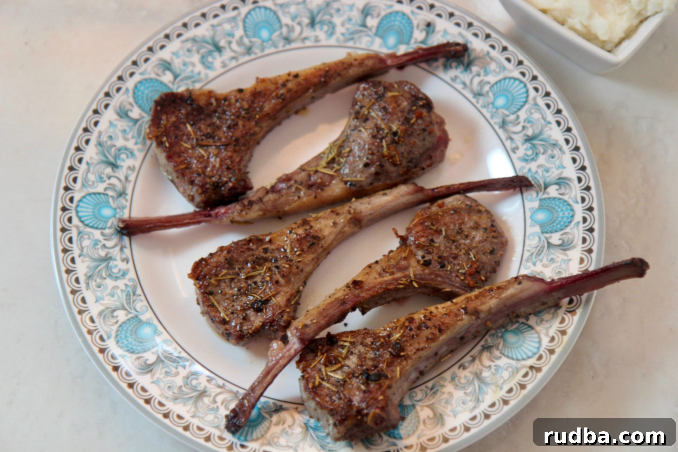 Close-up of perfectly cooked lamb chops, showcasing a golden-brown sear and visible juiciness.