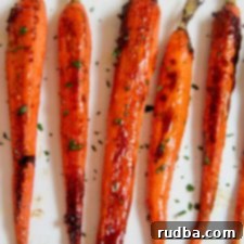 Caramelized Honey Carrots 2 Roasted carrots garnished with fresh parsley on a serving dish.