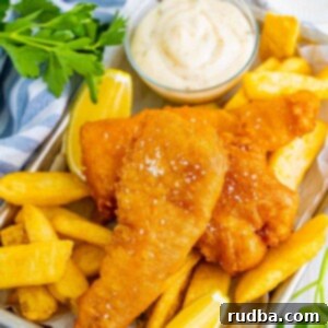 Classic Crispy Beer-Battered Fish 2 Crispy beer-battered cod fish with chips, lemon wedges, a sprinkle of salt, and a side of creamy tartar sauce.
