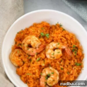creamy tomato orzo with shrimp in a white bowl.
