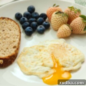 Perfectly Flipped Eggs 2 over easy egg with runny yolk, toast, and berries on the side.