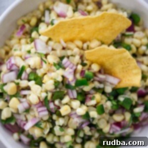 Fire Roasted Corn and Chili Salsa 2 Roasted chili corn salsa in a bowl with tortilla chips, garnished with fresh cilantro.