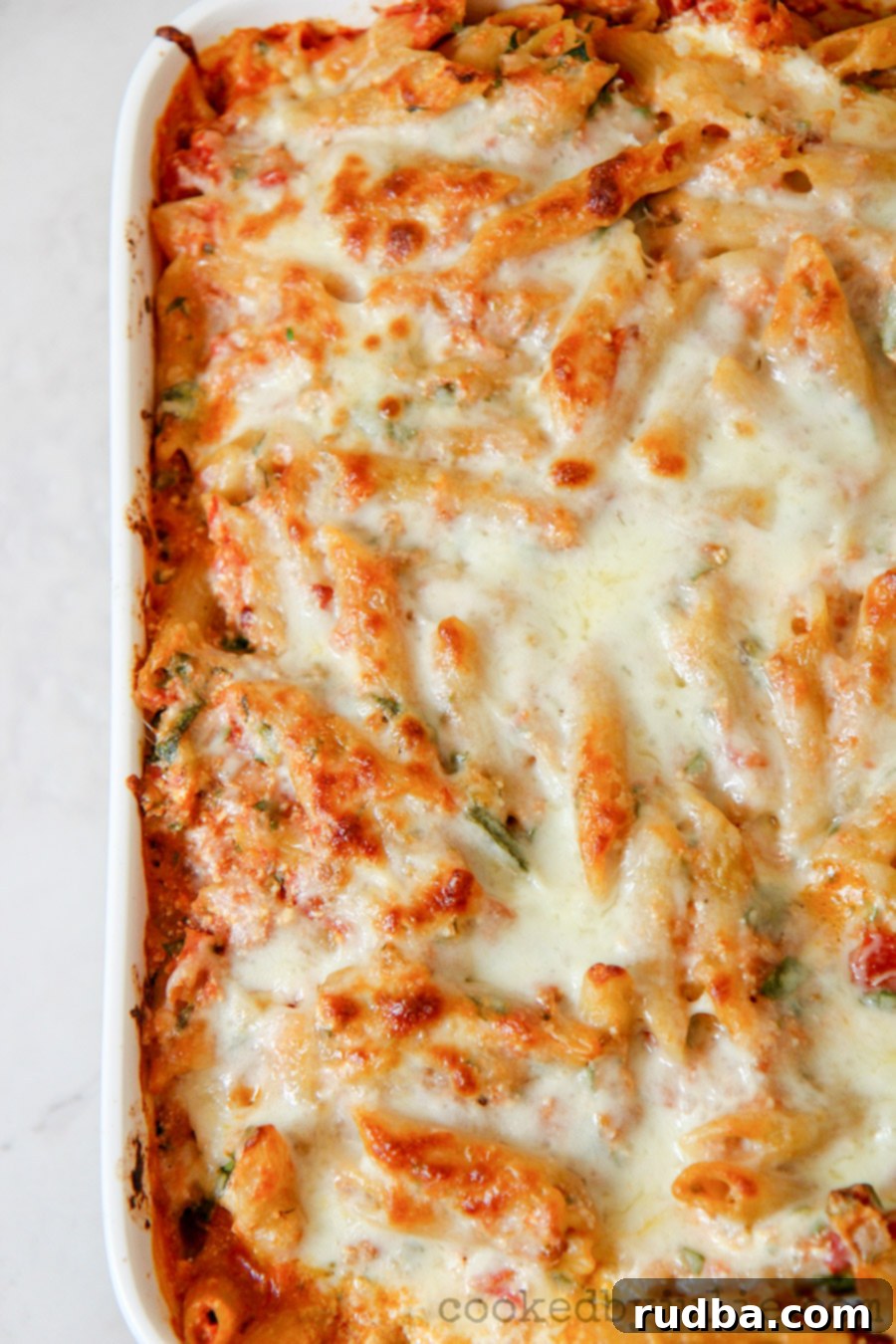 penne pasta with spinach and cheese in a casserole dish 