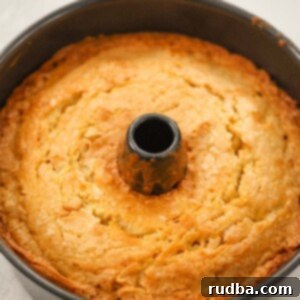 A golden-brown Million Dollar Pound Cake, freshly baked in a tube pan and ready to be served.