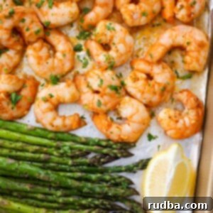 baked shrimp and asparagus with lemon wedges.
