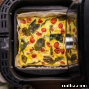 Effortless Air Fryer Frittata 2 A frittata, golden and fluffy, cooked to perfection in an air fryer basket.