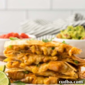 Savory Shrimp Quesadillas 2 four shrimp quesadillas stacked with limes and guacamole on the side.