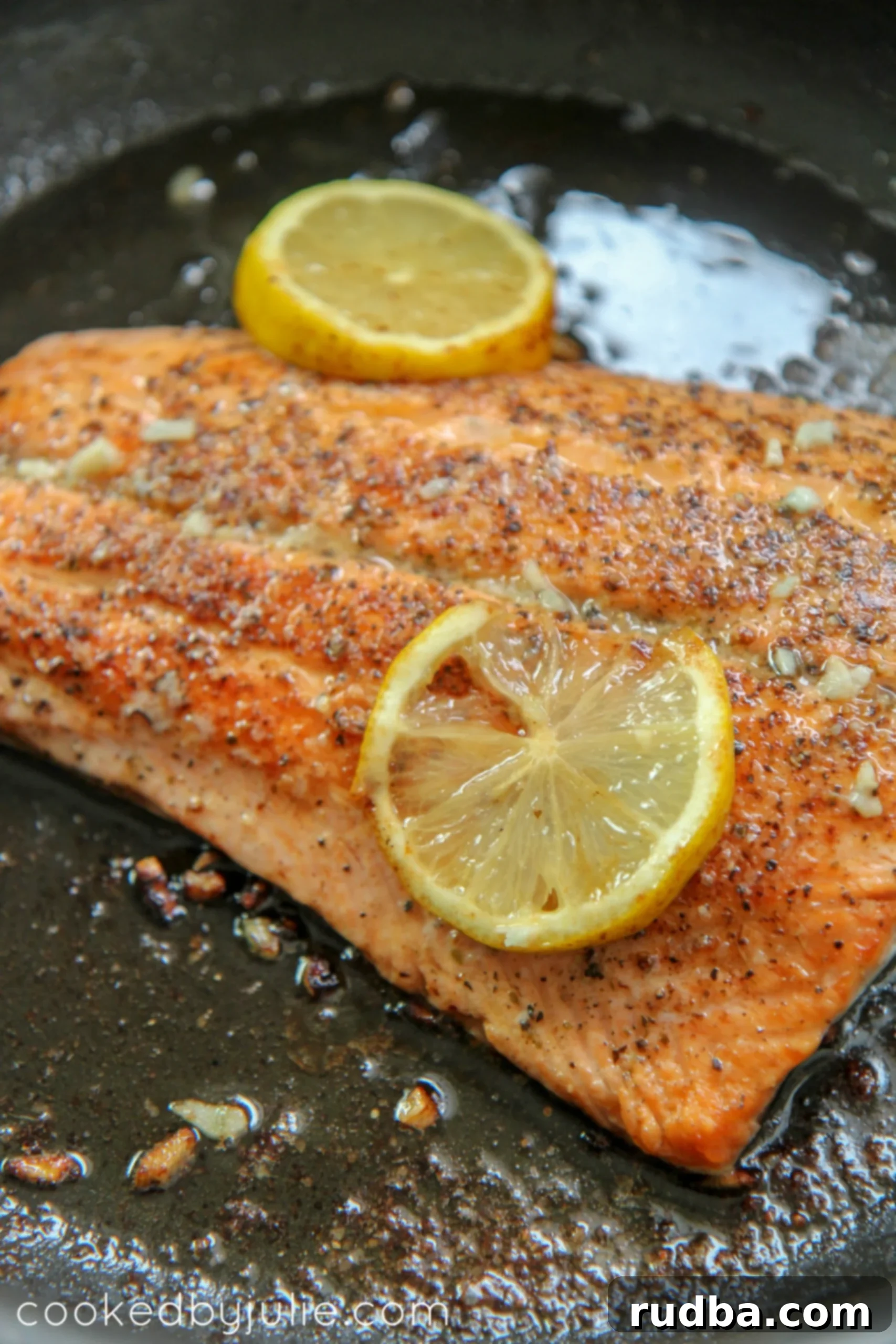 seared salmon with lemon in a black skillet
