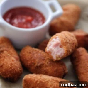 Crispy Golden Ham Croquettes 2 croquetas de jamon with ketchup on the side.