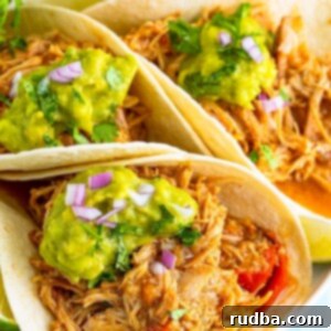 Easy Crockpot Shredded Chicken Tacos 2 Three shredded chicken tacos with guacamole on top.