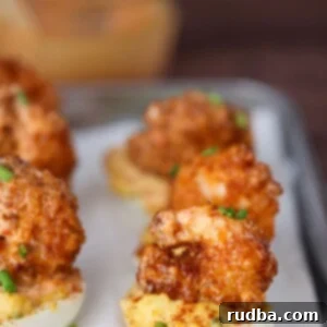 Crispy Shrimp Deviled Eggs 2 fried shrimp deviled eggs on a plate.