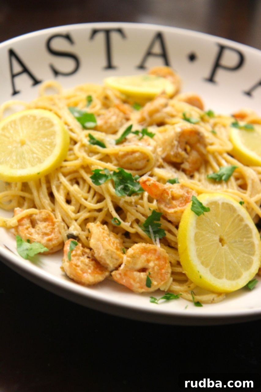 Close-up shot of creamy lemon garlic pasta with perfectly cooked shrimp, ideal for a romantic dinner.
