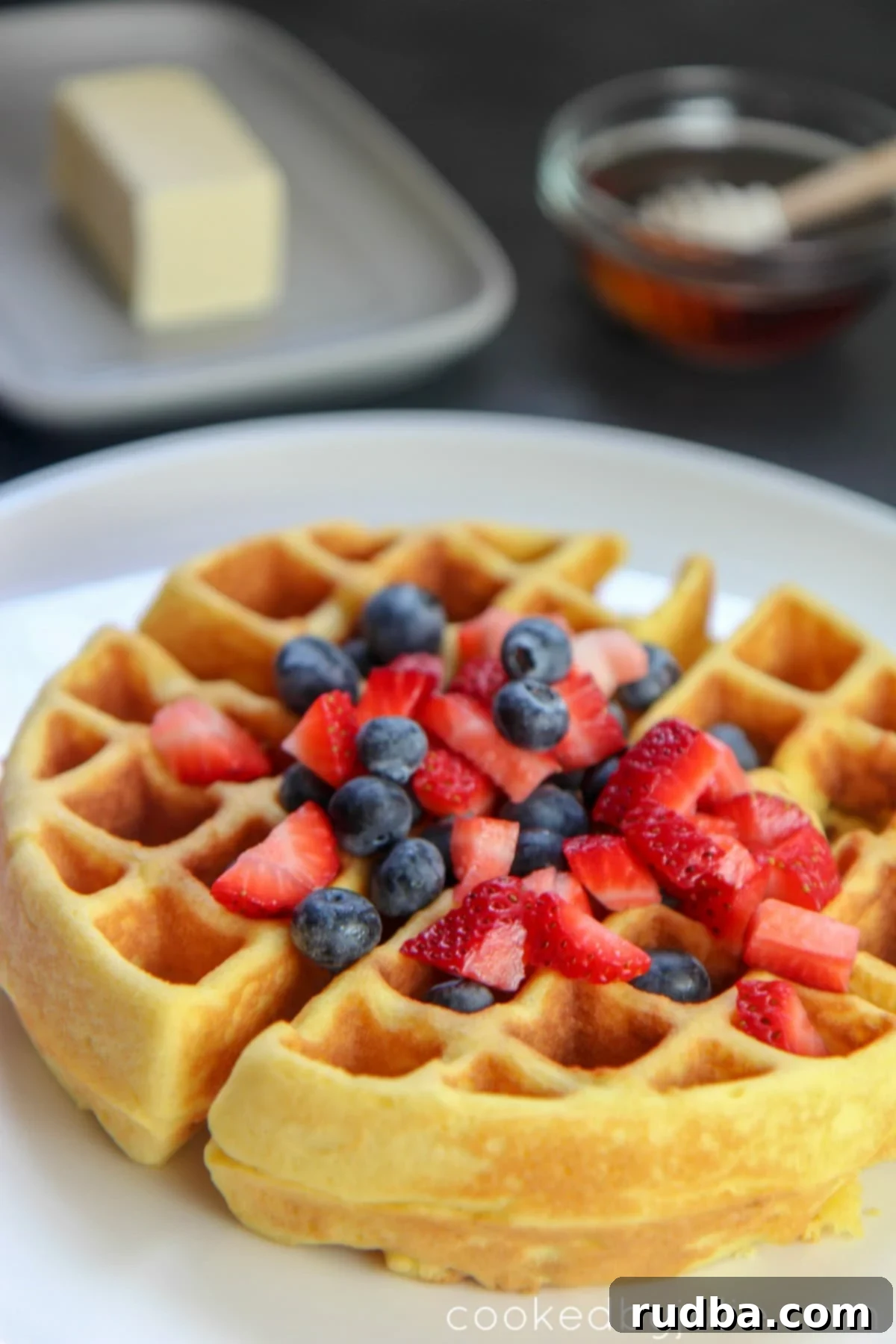 Fluffy Keto Belgian Waffle served with fresh strawberries and blueberries, drizzled with sugar-free syrup