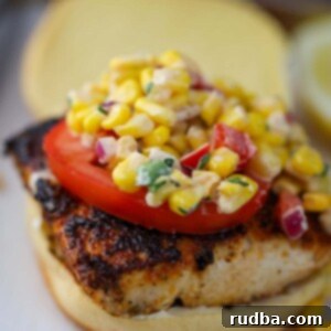 Tropical Mahi Sandwich 2 mahi mahi sandwich with corn salad on top.