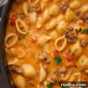 Taco pasta in a skillet up close, highlighting the creamy sauce, melted cheese, and seasoned ground beef.