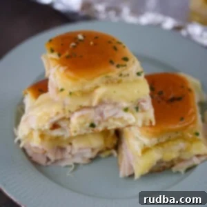Savory Turkey Havarti Sliders 2 turkey and havarti cheese sliders on a plate.