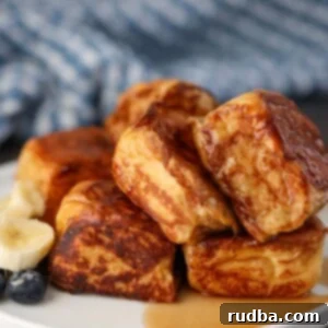 Sweet Hawaiian French Toast 2 Hawaiian roll French toast with syrup and fruit on the side.