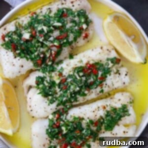 Zesty Chimichurri Cod Bake 2 Three cod fillets with chimichurri on top and lemon wedges on the side.