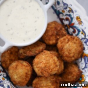 Crispy Southern Fried Pickles 2 Southern fried pickles with ranch dip on the side.
