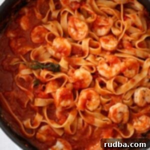 Spicy Shrimp Arrabbiata 2 shrimp arrabbiata with tagliatelle in a black skillet.