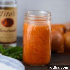 Velvet Tomato Vodka Sauce 2 A mason jar filled with creamy vodka sauce, garnished with fresh herbs.