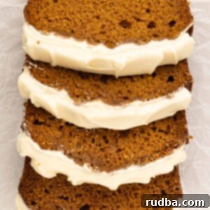 four slices of pumpkin bread with cream cheese frosting.
