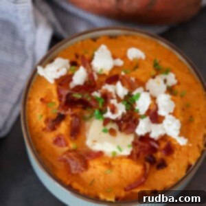 Creamy Sweet Potato Mash with Tangy Goat Cheese and Crispy Bacon 2 mashed sweet potatoes with goat cheese and bacon on top.