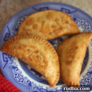 Savory Ground Beef Empanadas 2 Three ground beef empanadas on a blue plate.
