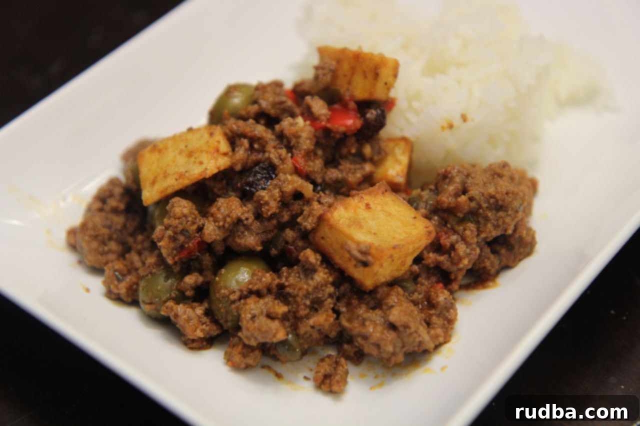 A healthy serving of Cuban Picadillo con Papas served alongside fluffy white rice.