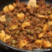 Classic Cuban Picadillo with Potatoes 5 A dish of Cuban Picadillo con Papas served with white rice, garnished with fresh cilantro.