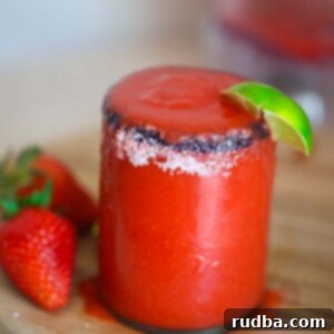Strawberry Frost Margarita 2 frozen strawberry margarita in a glass with salt on the rim.