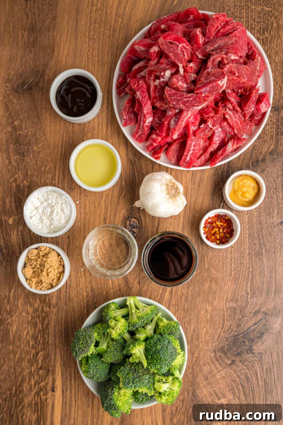 Classic Beef and Broccoli Stir Fry 3 Assortment of fresh ingredients including beef, broccoli, soy sauce, and spices on a rustic wooden surface.