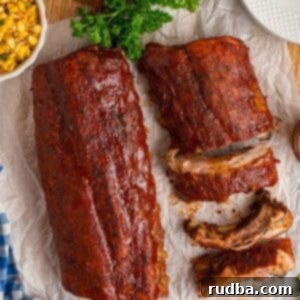 Ultimate Oven Baked BBQ Ribs 6 Two pork rib slabs with bbq sauce on top.
