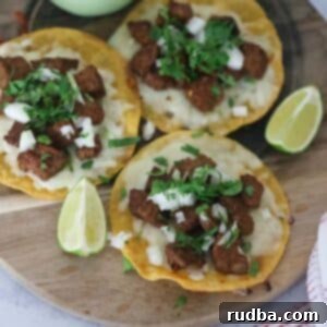 Sizzling Steak Tacos 6 Three steak tacos with lime wedges and avocado crema on the side.
