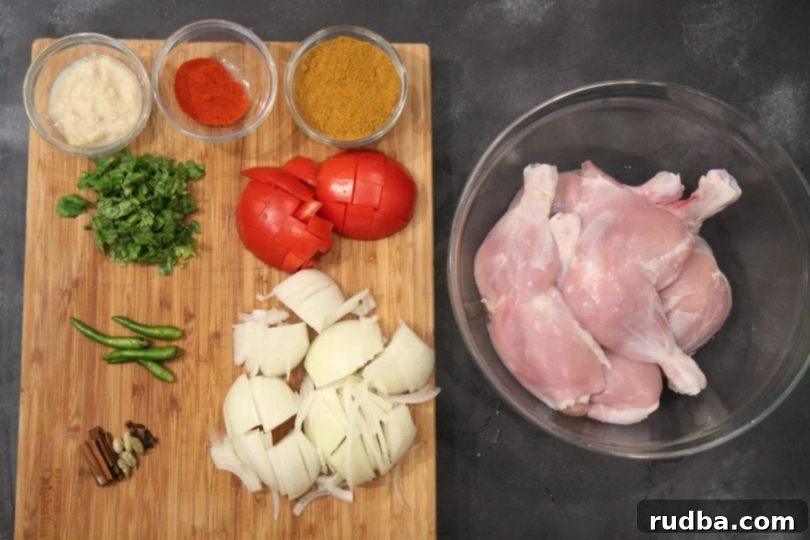 Chicken, onions, tomatoes and spices on a cutting board