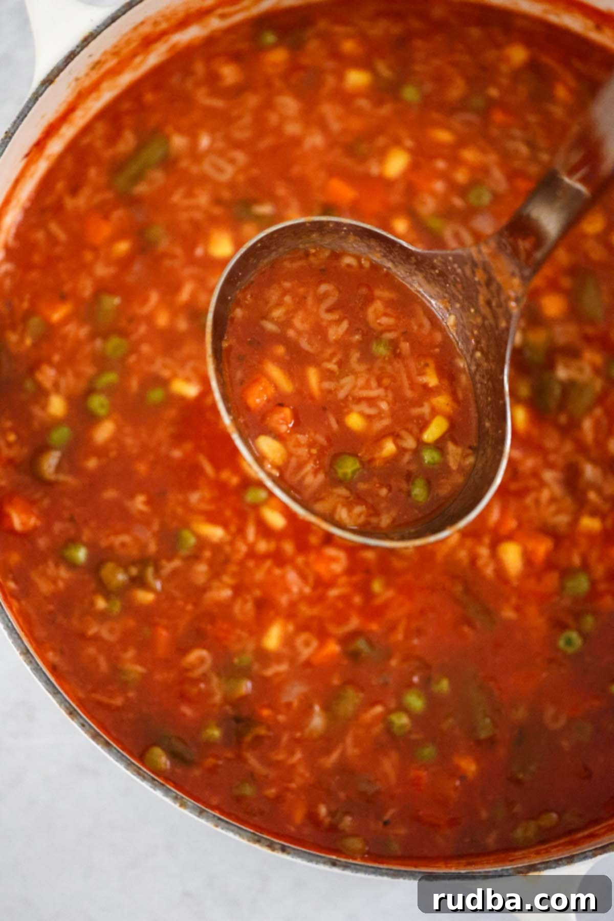 Word Alchemy 4 A large, rustic Dutch oven brimming with alphabet soup, with a serving ladle resting inside. Steam gently rises from the hot, comforting soup, inviting you to enjoy a warm meal. The scene suggests fresh, homemade goodness.