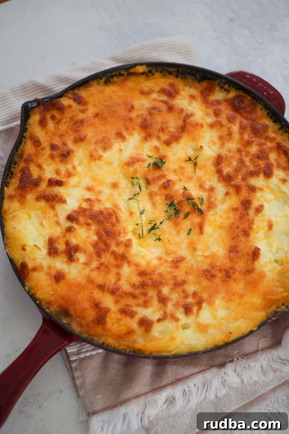 Golden Crust Beef and Mash 2 Cottage pie in a red skillet, bubbling hot from the oven.